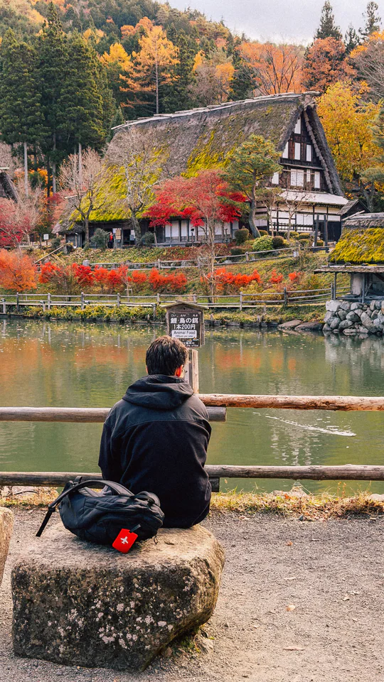 A serene autumn day in Shirakawa-go, Japan, featuring traditional gassho-style homes with vibrant fall foliage.