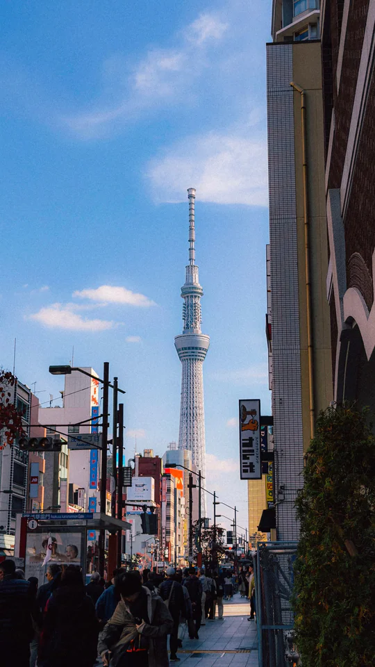 View of Tokyo Skytree amidst urban scenery with people on the street.
