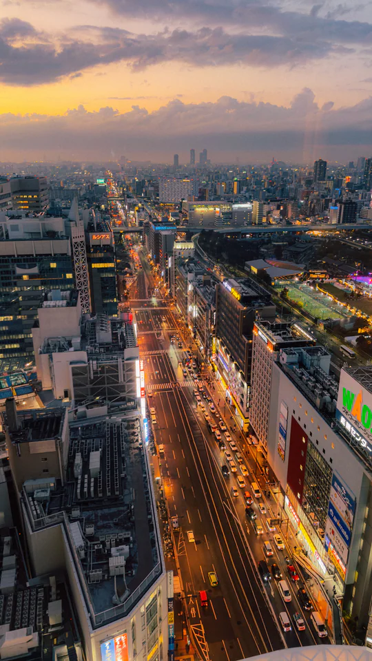 Aerial view of Tokyo's bustling streets and city lights at dusk, showcasing the city's vibrant urban landscape.