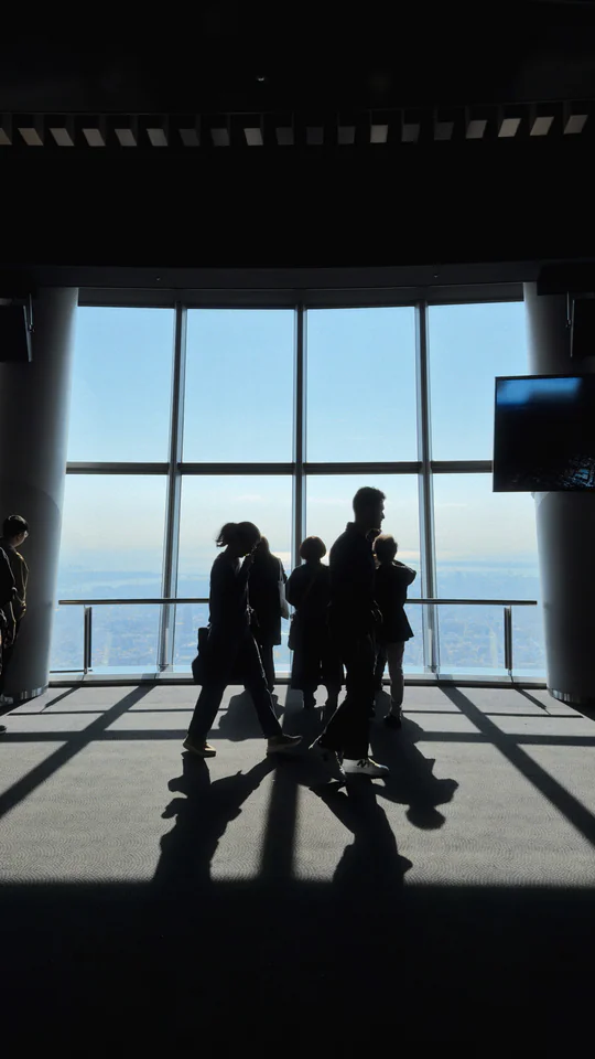 Visitors silhouetted against the panoramic view from Tokyo Skytree's observation deck.